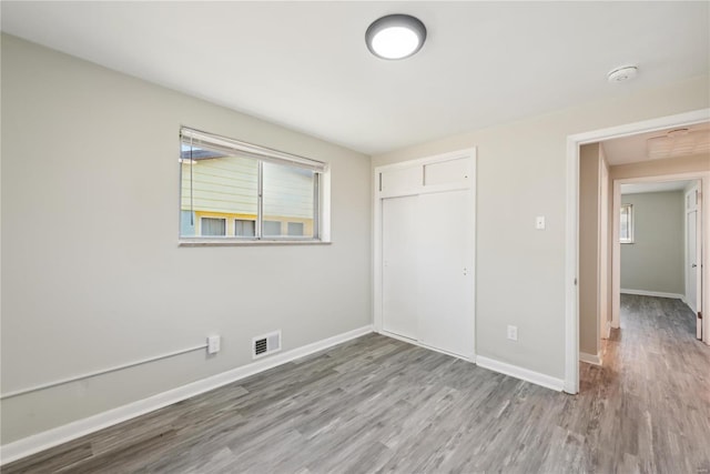 7921 Glenside Pl, Saint Louis, MO 63130 - unfurnished bedroom featuring wood finished floors, a closet, and baseboards