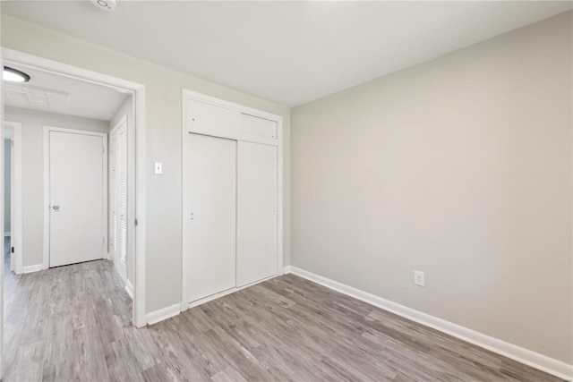 7921 Glenside Pl, Saint Louis, MO 63130 - unfurnished bedroom featuring light wood-style flooring, baseboards, and a closet