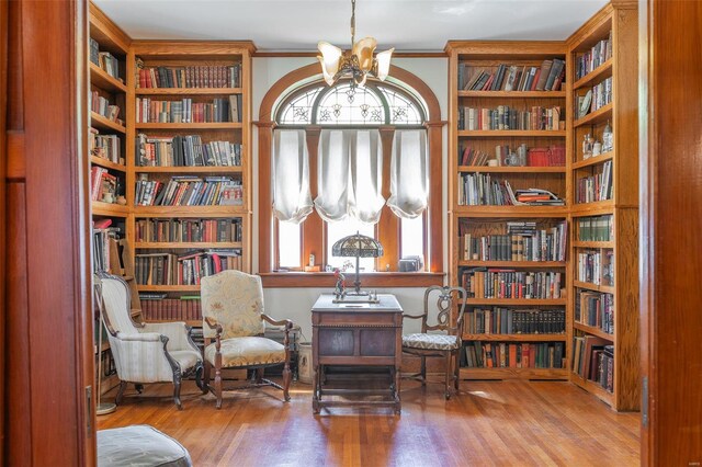 sitting room featuring bookshelves and wood finished floors