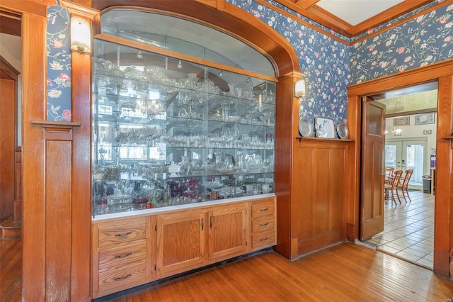 indoor bar with wallpapered walls, wood finished floors, and french doors