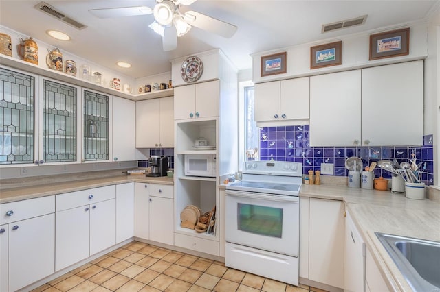kitchen featuring white appliances, a sink, tasteful backsplash, light countertops, and crown molding