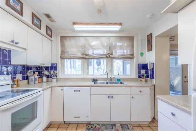 kitchen with white appliances, a sink, plenty of natural light, backsplash, and ornamental molding