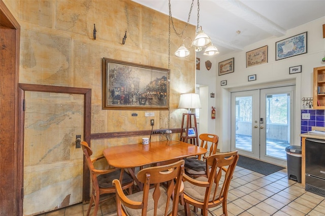 dining space with french doors, light tile patterned flooring, and beamed ceiling