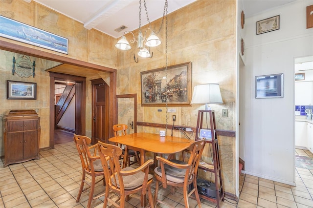 dining room featuring light tile patterned floors, a towering ceiling, and a chandelier