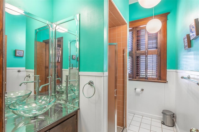 full bathroom with wainscoting, tile patterned floors, vanity, and an enclosed shower