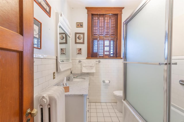 bathroom featuring tile walls, tile patterned floors, radiator, an enclosed shower, and toilet