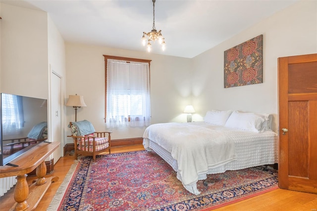 bedroom with wood finished floors and a chandelier