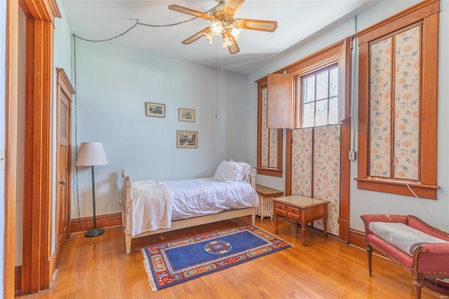 bedroom with wood finished floors, baseboards, and a ceiling fan