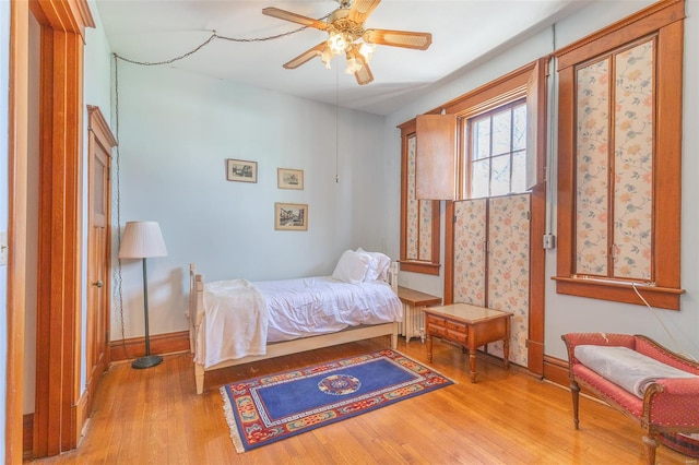 bedroom featuring wood finished floors, baseboards, and ceiling fan