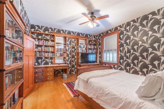 bedroom featuring wallpapered walls and light wood-style flooring
