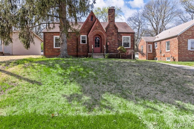 1825 S New Florissant Rd, Florissant, MO 63031 - tudor house with brick siding, a chimney, and a front lawn