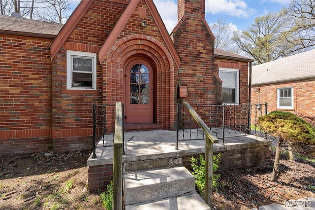 1825 S New Florissant Rd, Florissant, MO 63031 - entrance to property featuring a chimney, brick siding, and a shingled roof