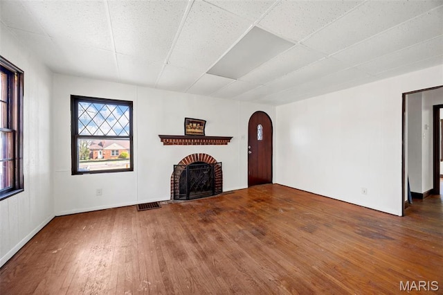 1825 S New Florissant Rd, Florissant, MO 63031 - unfurnished living room featuring hardwood / wood-style floors, arched walkways, a fireplace, and a paneled ceiling