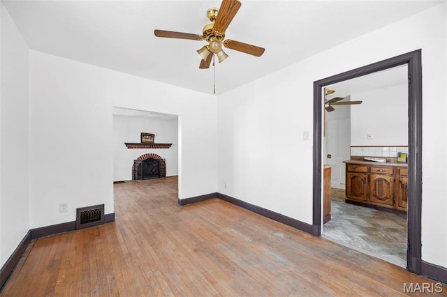 1825 S New Florissant Rd, Florissant, MO 63031 - unfurnished living room featuring ceiling fan, a fireplace, hardwood / wood-style floors, and baseboards
