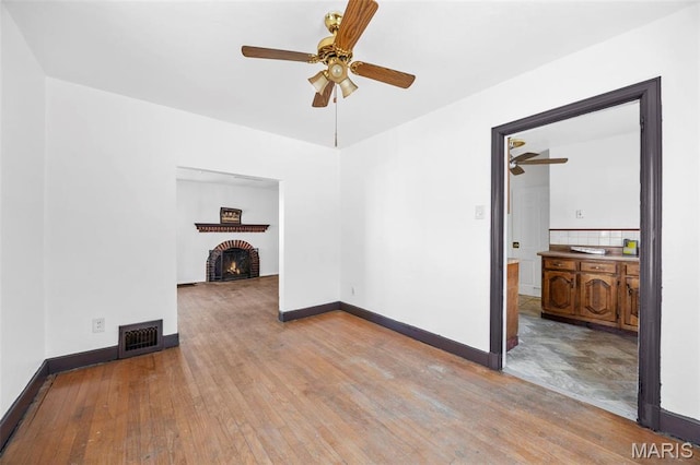 1825 S New Florissant Rd, Florissant, MO 63031 - unfurnished living room featuring ceiling fan, hardwood / wood-style floors, a fireplace, and baseboards