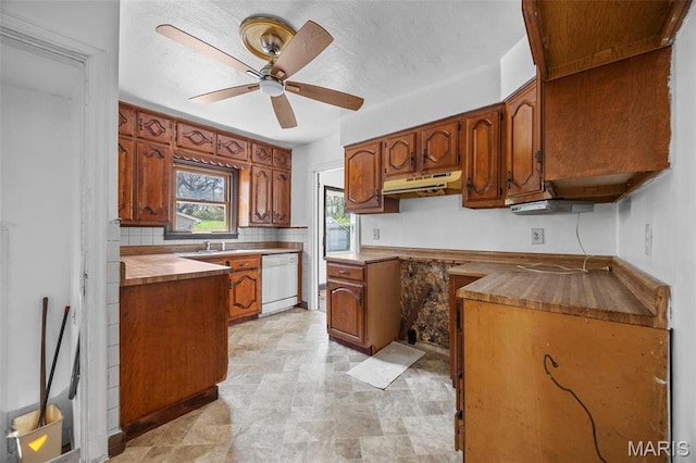 1825 S New Florissant Rd, Florissant, MO 63031 - kitchen featuring dishwasher, a ceiling fan, brown cabinets, under cabinet range hood, and decorative backsplash