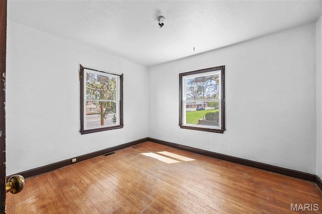 1825 S New Florissant Rd, Florissant, MO 63031 - empty room featuring plenty of natural light, hardwood / wood-style flooring, and baseboards