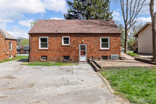 1825 S New Florissant Rd, Florissant, MO 63031 - back of property with central air condition unit, roof with shingles, a patio, and brick siding