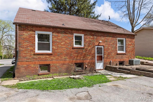 1825 S New Florissant Rd, Florissant, MO 63031 - rear view of house featuring brick siding, central AC, and roof with shingles