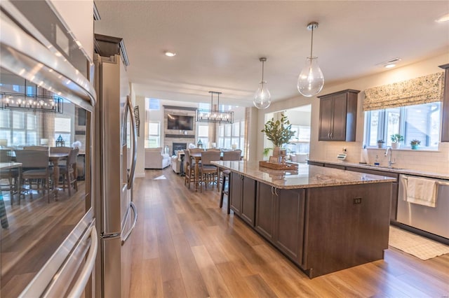 6380 Gateway Arch Way, Ashland, MO 65010 - kitchen featuring stainless steel dishwasher, a chandelier, dark brown cabinetry, light stone countertops, and recessed lighting