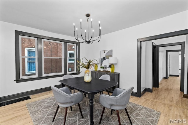 6007 S Kingshighway Blvd S, Saint Louis, MO 63109 - dining space featuring a chandelier, light wood-type flooring, and baseboards