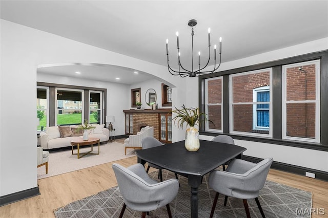 6007 S Kingshighway Blvd S, Saint Louis, MO 63109 - dining space with arched walkways, wood finished floors, a chandelier, and baseboards