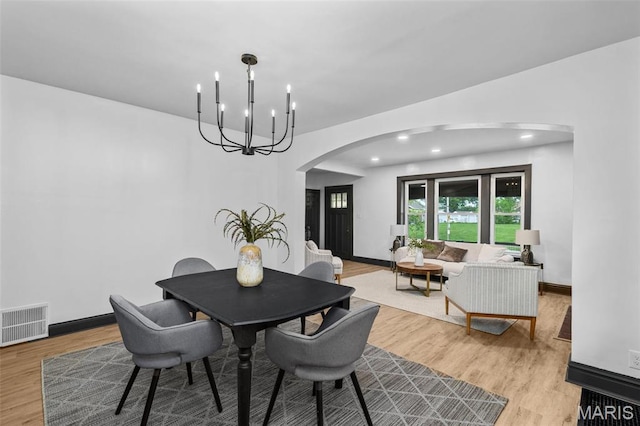 6007 S Kingshighway Blvd S, Saint Louis, MO 63109 - dining space with arched walkways, light wood finished floors, a chandelier, recessed lighting, and baseboards