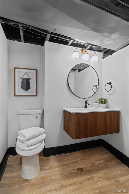 6007 S Kingshighway Blvd S, Saint Louis, MO 63109 - bathroom with toilet, baseboards, wood finished floors, and vanity