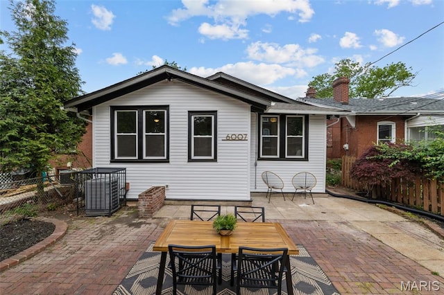 6007 S Kingshighway Blvd S, Saint Louis, MO 63109 - back of property with a patio, fence, central AC, and a chimney