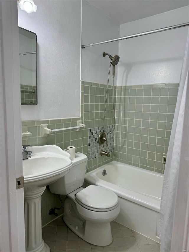 4400 Mohegan Dr, Saint Louis, MO 63123 - bathroom with tile walls, tile patterned floors, toilet, washtub / shower combination, and a wainscoted wall