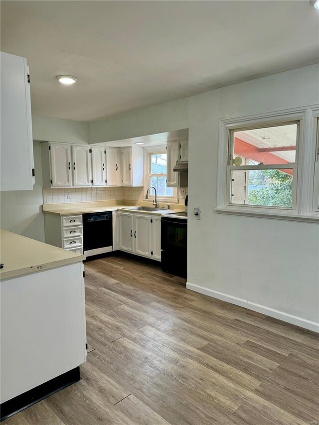 4400 Mohegan Dr, Saint Louis, MO 63123 - kitchen with black appliances, white cabinets, wood finished floors, light countertops, and a sink