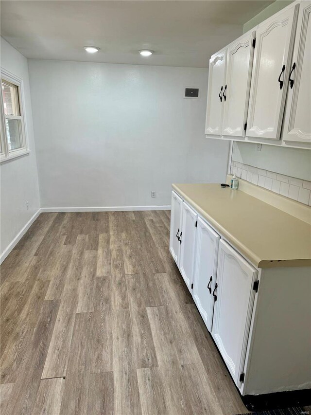 4400 Mohegan Dr, Saint Louis, MO 63123 - laundry room featuring wood finished floors, baseboards, and recessed lighting