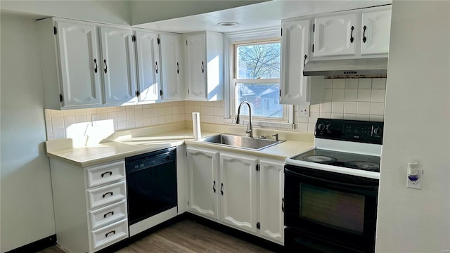 4400 Mohegan Dr, Saint Louis, MO 63123 - kitchen with black dishwasher, range with electric cooktop, a sink, under cabinet range hood, and white cabinetry
