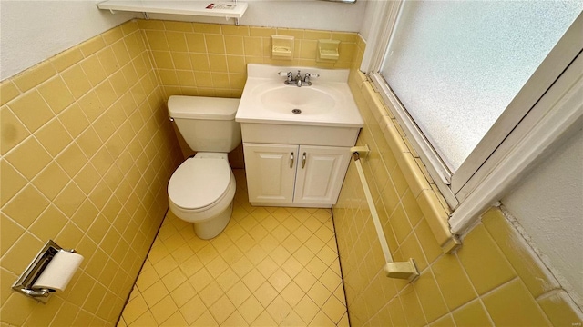 4400 Mohegan Dr, Saint Louis, MO 63123 - half bath with vanity, tile walls, toilet, and tile patterned flooring