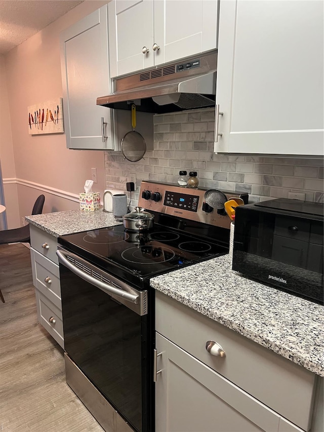 572 Coeur De Royale Unit 103, Creve Coeur, MO 63141 - kitchen featuring stainless steel electric stove, under cabinet range hood, black microwave, light wood-type flooring, and backsplash