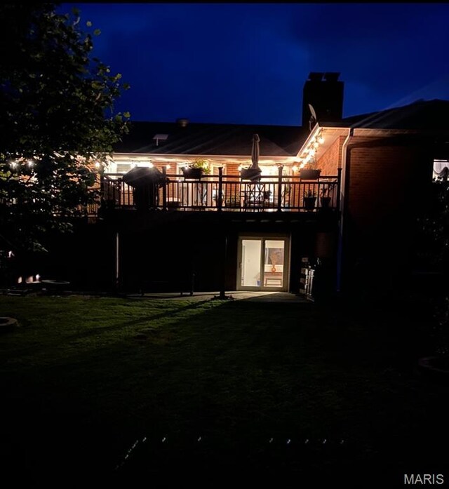 705 Linder Blvd, Greenville, IL 62246 - back of house at twilight featuring a chimney, a wooden deck, and a patio