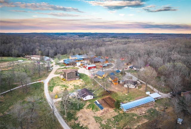 aerial view of property and surrounding area featuring a forest