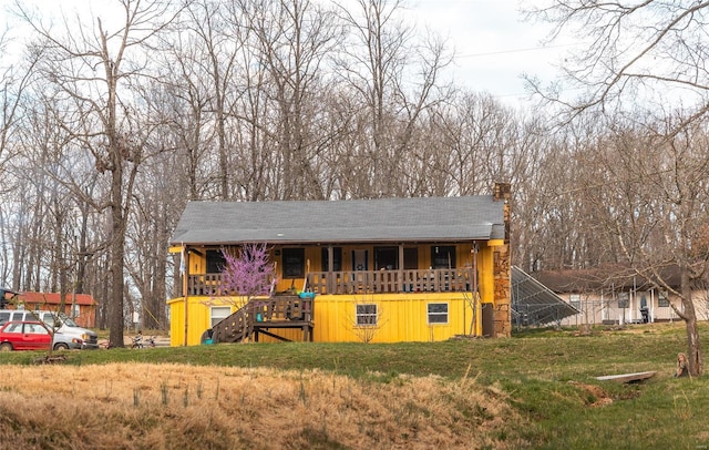 view of front of property featuring a chimney, stairway, a porch, and a front yard