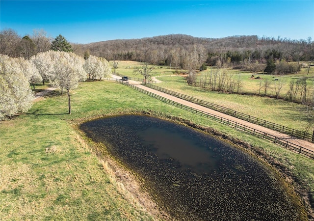 view of yard featuring a view of countryside, a water view, and a wooded view