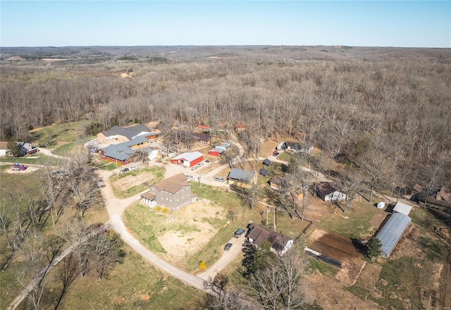 aerial view of property and surrounding area featuring a forest