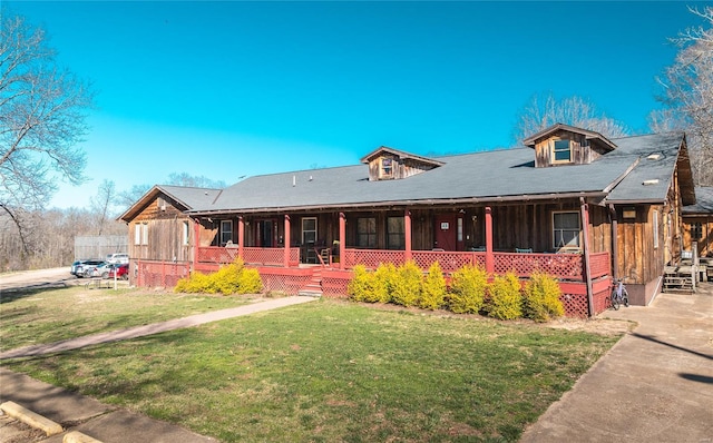 view of front of property featuring covered porch, a front yard, and board and batten siding