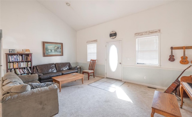 carpeted living area with healthy amount of natural light and high vaulted ceiling