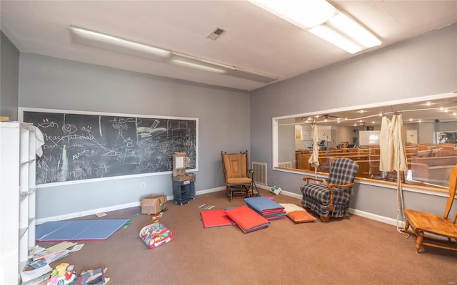 game room with carpet floors, a wood stove, and baseboards