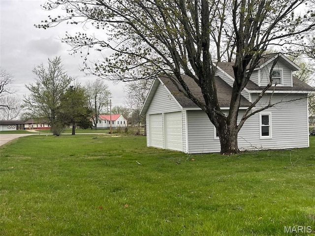 view of green lawn with a garage