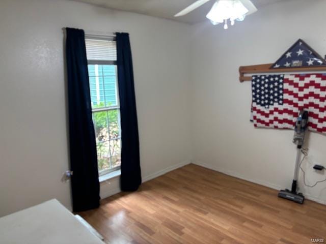 unfurnished bedroom featuring light wood-type flooring, multiple windows, and baseboards