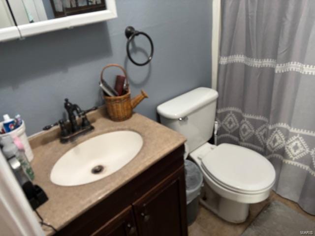 bathroom with toilet, vanity, and a shower with shower curtain