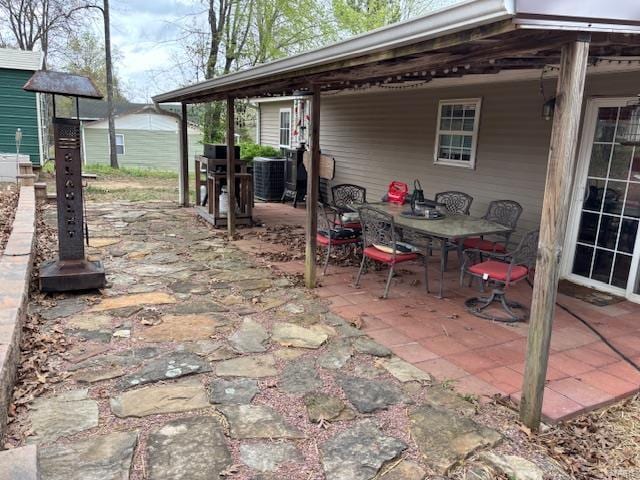 view of patio with outdoor dining area and central AC unit