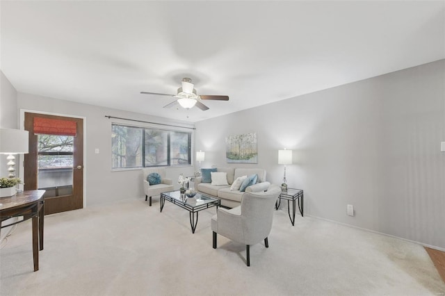 carpeted living room with a ceiling fan and baseboards