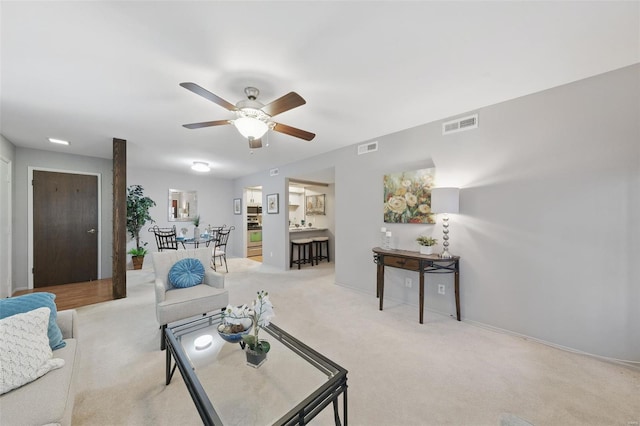 living area featuring carpet floors, a ceiling fan, and baseboards