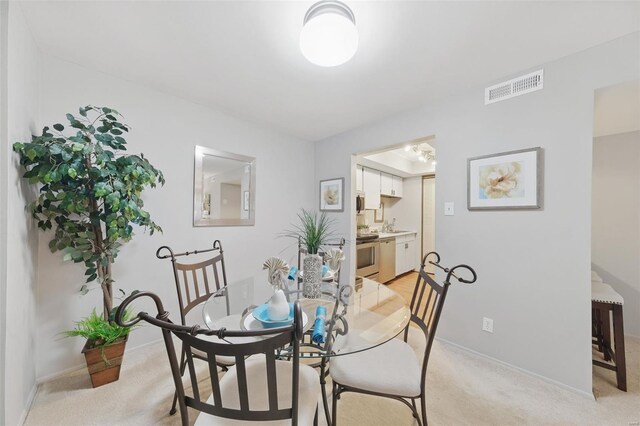 dining room with light carpet and baseboards